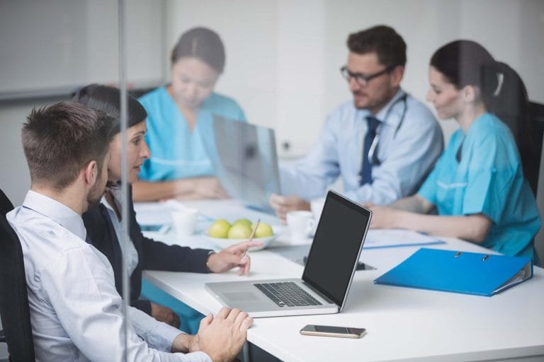 Clinic CQC registration: a clinic team meeting around a laptop