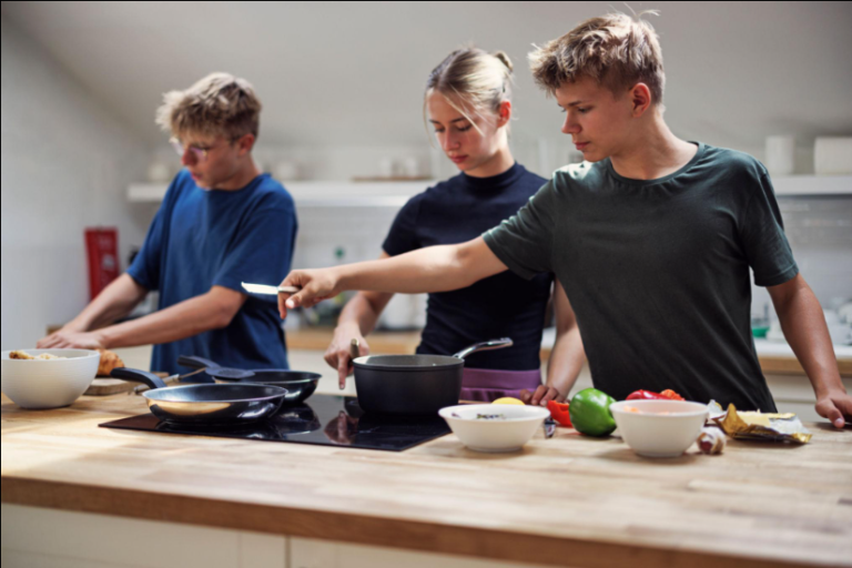 Ofsted supported accommodation registration package: young people cooking together in a shared kitchen